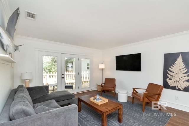 living room featuring hardwood / wood-style flooring, ornamental molding, and french doors