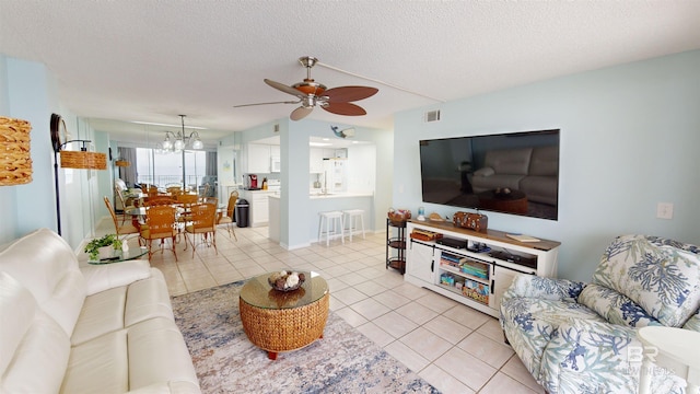 living room with a textured ceiling, ceiling fan with notable chandelier, and light tile patterned flooring