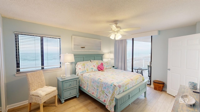 bedroom featuring a textured ceiling, light hardwood / wood-style flooring, and ceiling fan