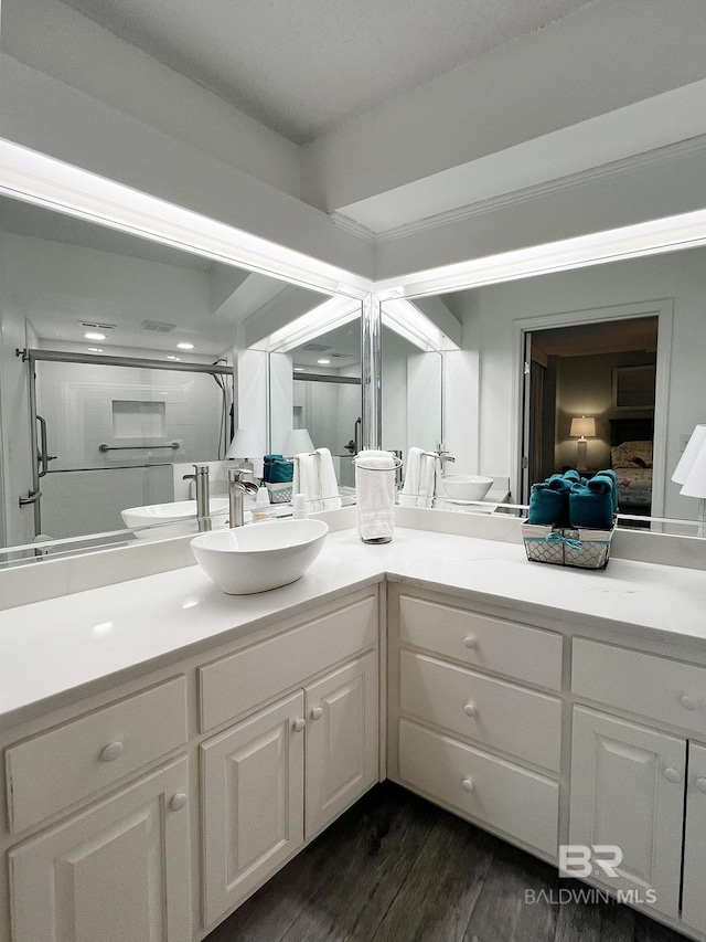 bathroom featuring hardwood / wood-style floors, vanity, and walk in shower