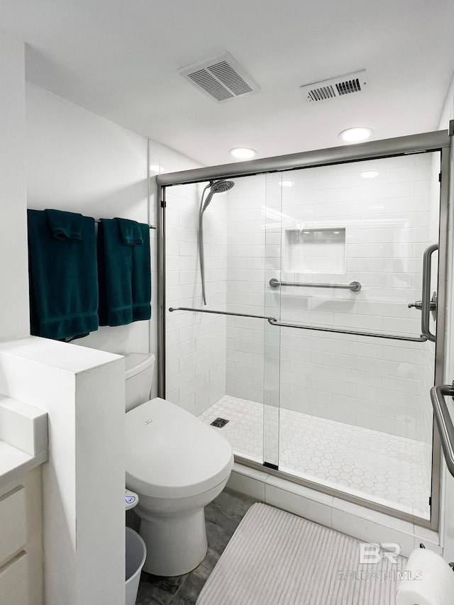 bathroom with vanity, toilet, and a shower with shower door