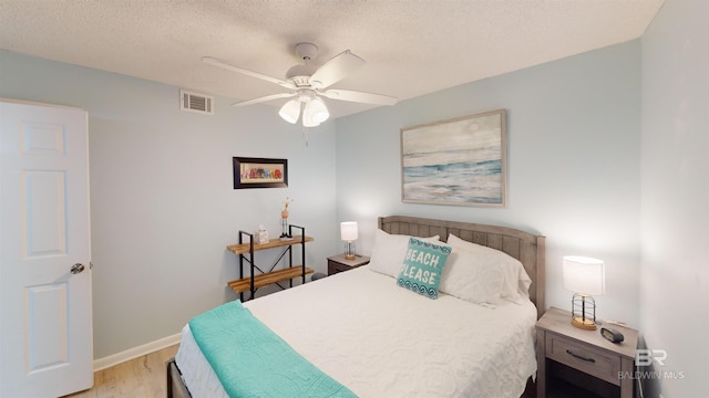 bedroom featuring a textured ceiling, light wood-type flooring, and ceiling fan