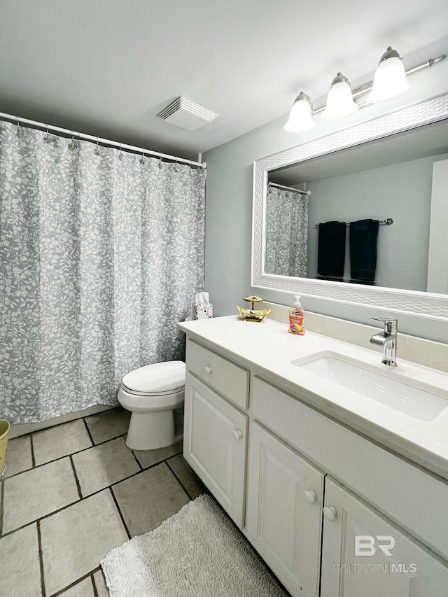 bathroom featuring tile patterned flooring, vanity, and toilet