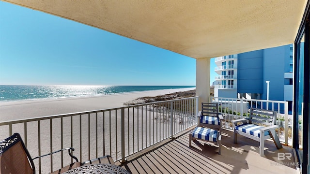 balcony featuring a beach view and a water view