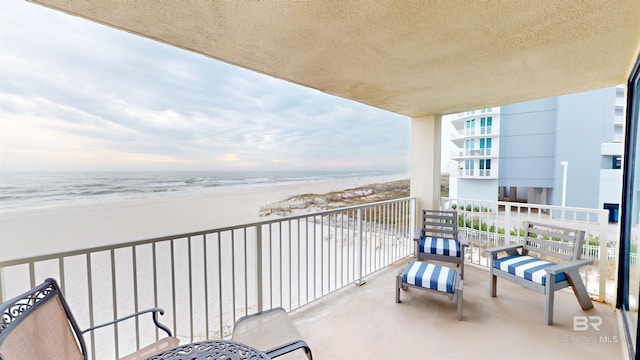 balcony featuring a water view and a beach view