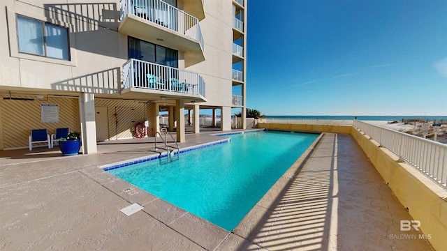 view of pool with a patio area and a water view