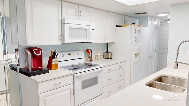 kitchen featuring white cabinets, white appliances, and sink