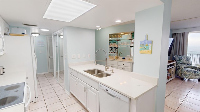 kitchen featuring white cabinetry, light tile patterned flooring, white appliances, and sink