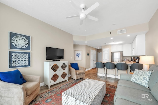 living area with baseboards, a ceiling fan, recessed lighting, and tile patterned flooring