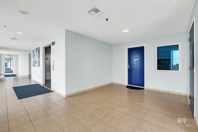 unfurnished room with light tile patterned floors, baseboards, recessed lighting, a pendent fire sprinkler, and elevator
