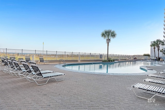 community pool with fence and a patio