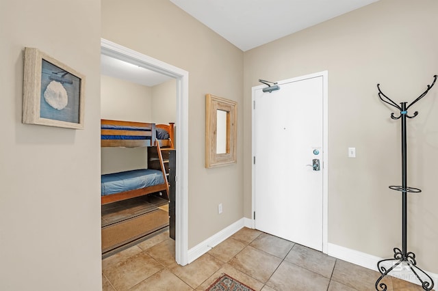 foyer with light tile patterned flooring and baseboards