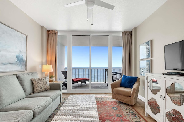 tiled living area featuring a ceiling fan and a textured ceiling