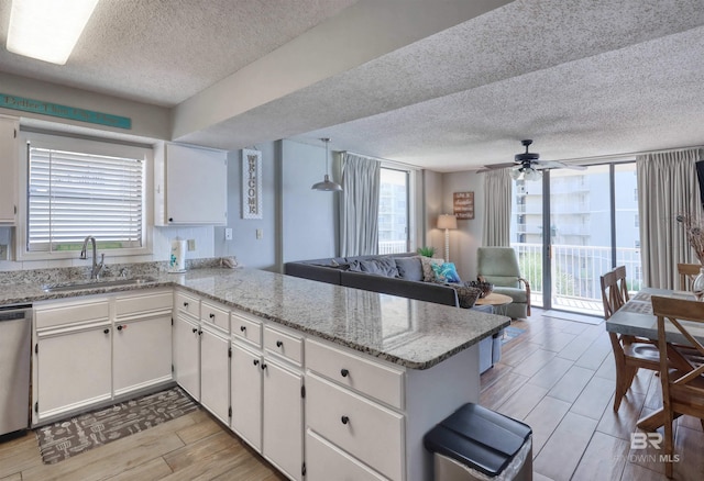 kitchen with a peninsula, plenty of natural light, wood tiled floor, and a sink