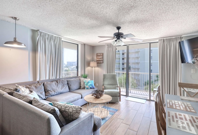 living area featuring ceiling fan, a textured ceiling, wood finished floors, and floor to ceiling windows