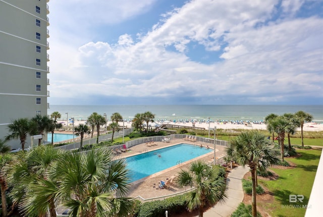 community pool featuring a water view and fence