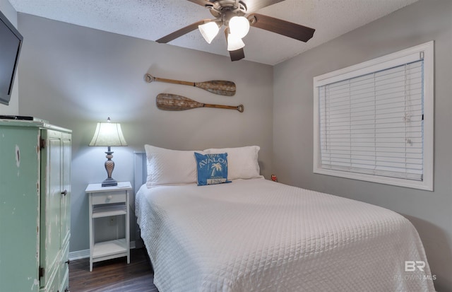 bedroom with a ceiling fan, a textured ceiling, and wood finished floors