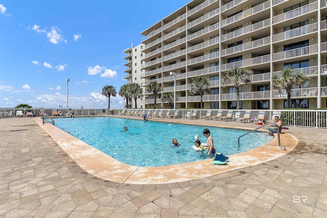 community pool with fence and a patio