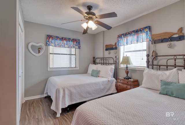 bedroom featuring baseboards, a ceiling fan, wood finished floors, a textured ceiling, and a closet