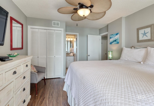 bedroom featuring a textured ceiling, dark wood-style flooring, a closet, and visible vents