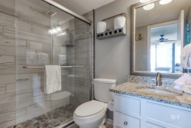 full bath featuring a textured ceiling, toilet, a shower stall, and vanity