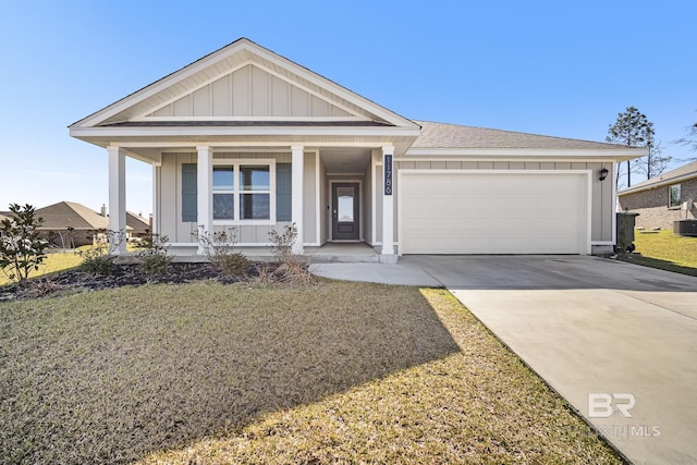 view of front of property with a shingled roof, concrete driveway, board and batten siding, a front yard, and a garage