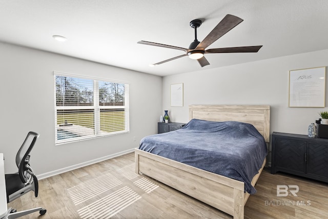 bedroom featuring ceiling fan, baseboards, and wood finished floors