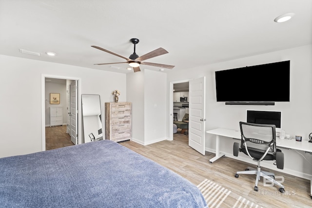 bedroom featuring visible vents, a spacious closet, connected bathroom, wood finished floors, and baseboards