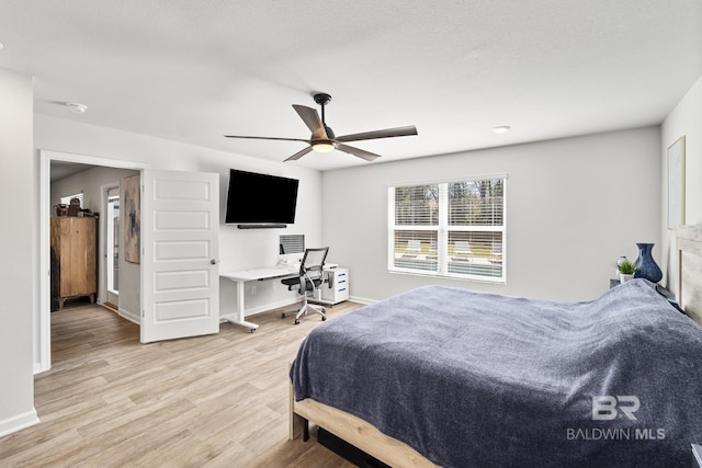 bedroom featuring a ceiling fan, baseboards, and light wood finished floors