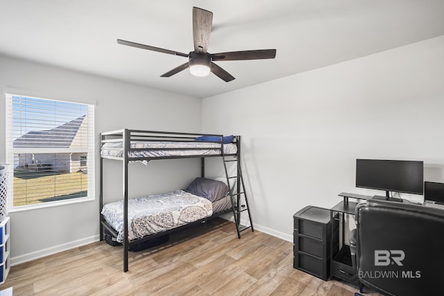 bedroom with wood finished floors, a ceiling fan, and baseboards