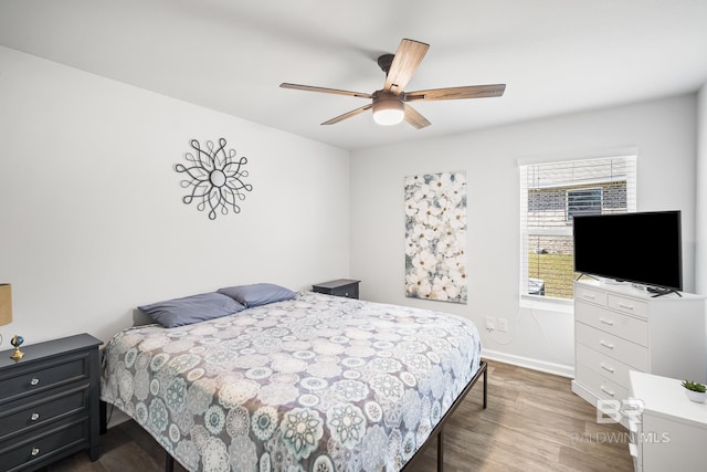 bedroom with ceiling fan, baseboards, and wood finished floors