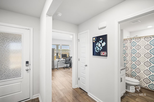 entryway with dark wood-type flooring and baseboards