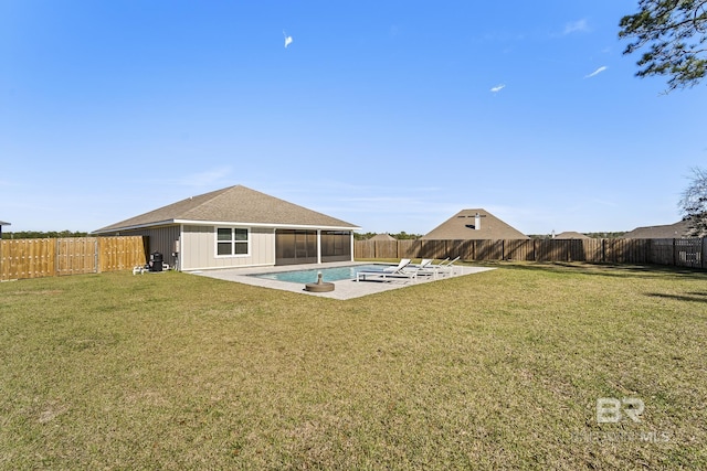 rear view of property featuring a lawn, a fenced backyard, and a sunroom