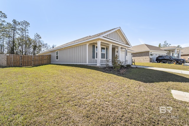 view of front of property featuring an attached garage, fence, a front lawn, and board and batten siding