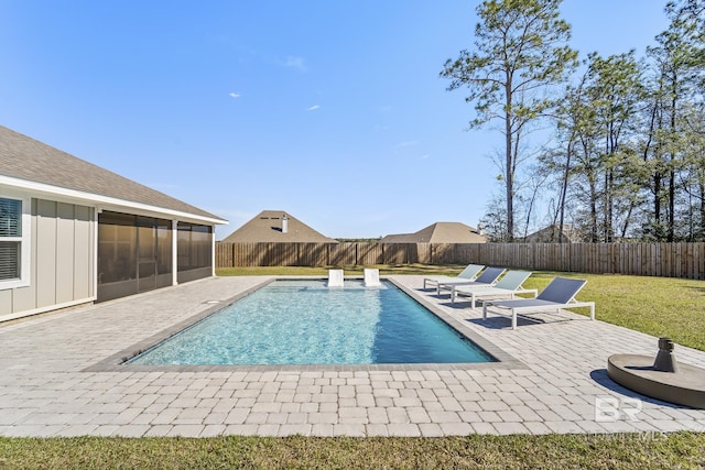 view of swimming pool with a lawn, a fenced in pool, a patio, a sunroom, and a fenced backyard