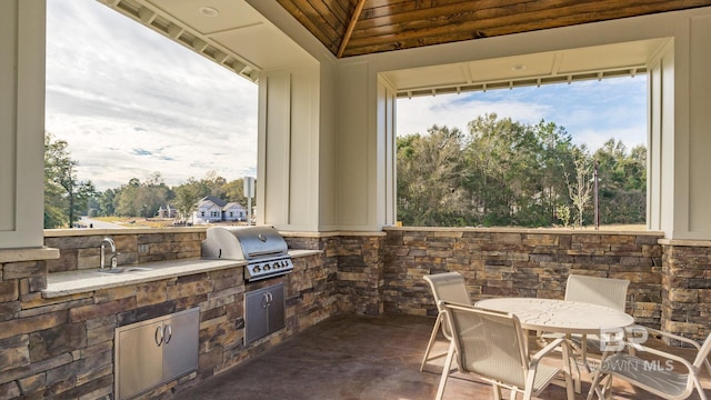 view of patio featuring outdoor dining space, area for grilling, and a sink