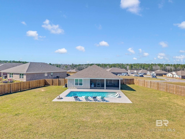 rear view of property featuring a yard, a fenced backyard, and a sunroom