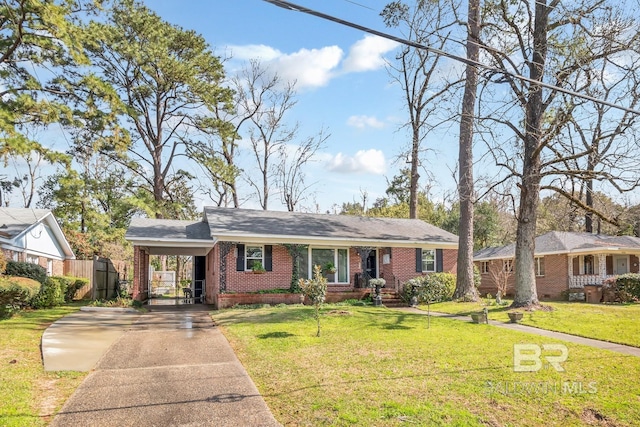 ranch-style house featuring brick siding, an attached carport, a front lawn, fence, and concrete driveway