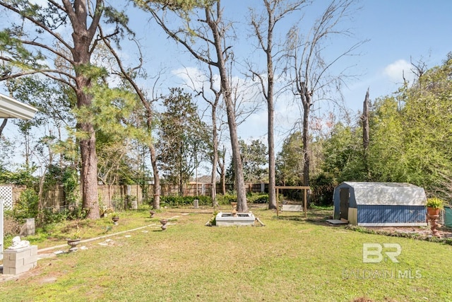 view of yard with an outdoor structure, fence, and a shed