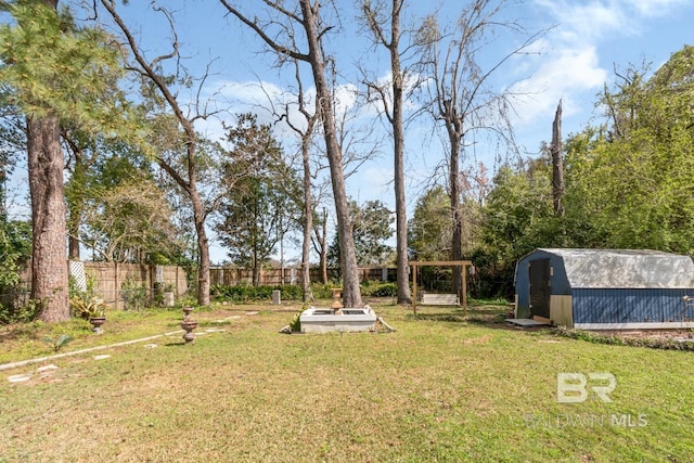 view of yard with a storage shed, an outdoor structure, and fence