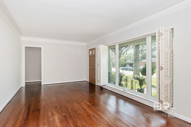 spare room with baseboards, wood finished floors, and ornamental molding