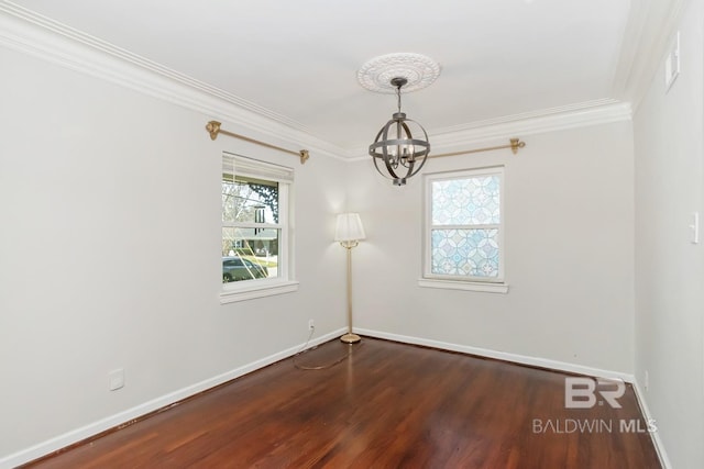 spare room with baseboards, dark wood-type flooring, an inviting chandelier, and crown molding