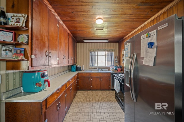 kitchen with light countertops, wooden ceiling, freestanding refrigerator, black electric range, and a sink