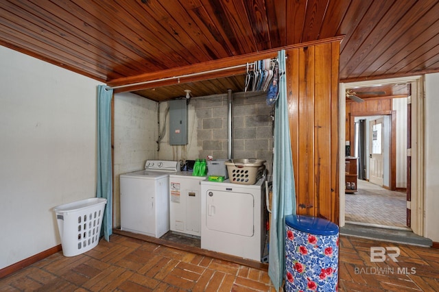 clothes washing area featuring electric panel, laundry area, wooden ceiling, brick floor, and washer and dryer