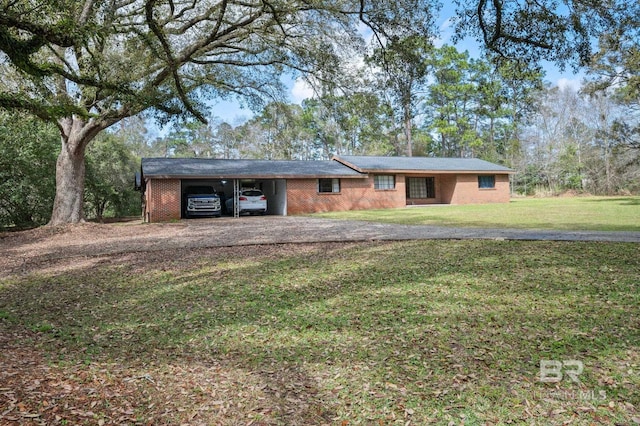 ranch-style house featuring an attached carport, a front lawn, brick siding, and driveway