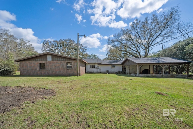 back of house with a yard and brick siding