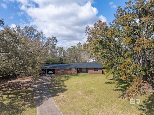 view of front facade featuring a carport, concrete driveway, a front yard, and brick siding