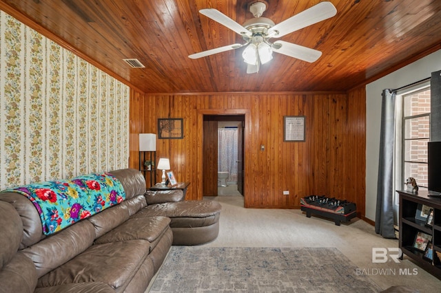 living area with wooden walls, visible vents, carpet floors, ceiling fan, and wooden ceiling