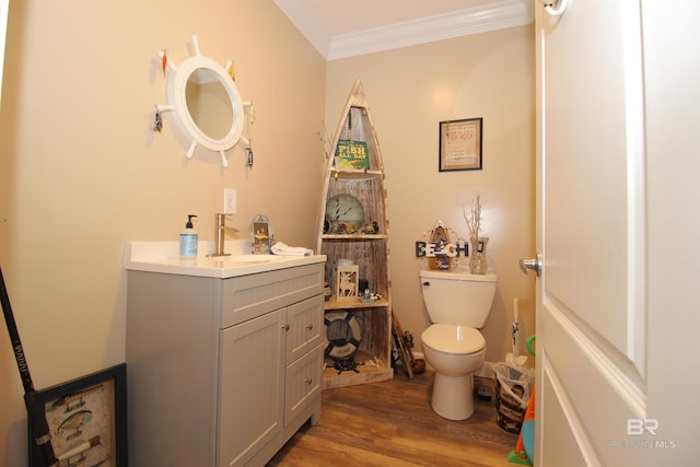 bathroom featuring toilet, ornamental molding, vanity, and wood-type flooring