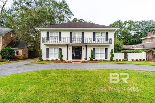 view of front of property with a front yard and a balcony